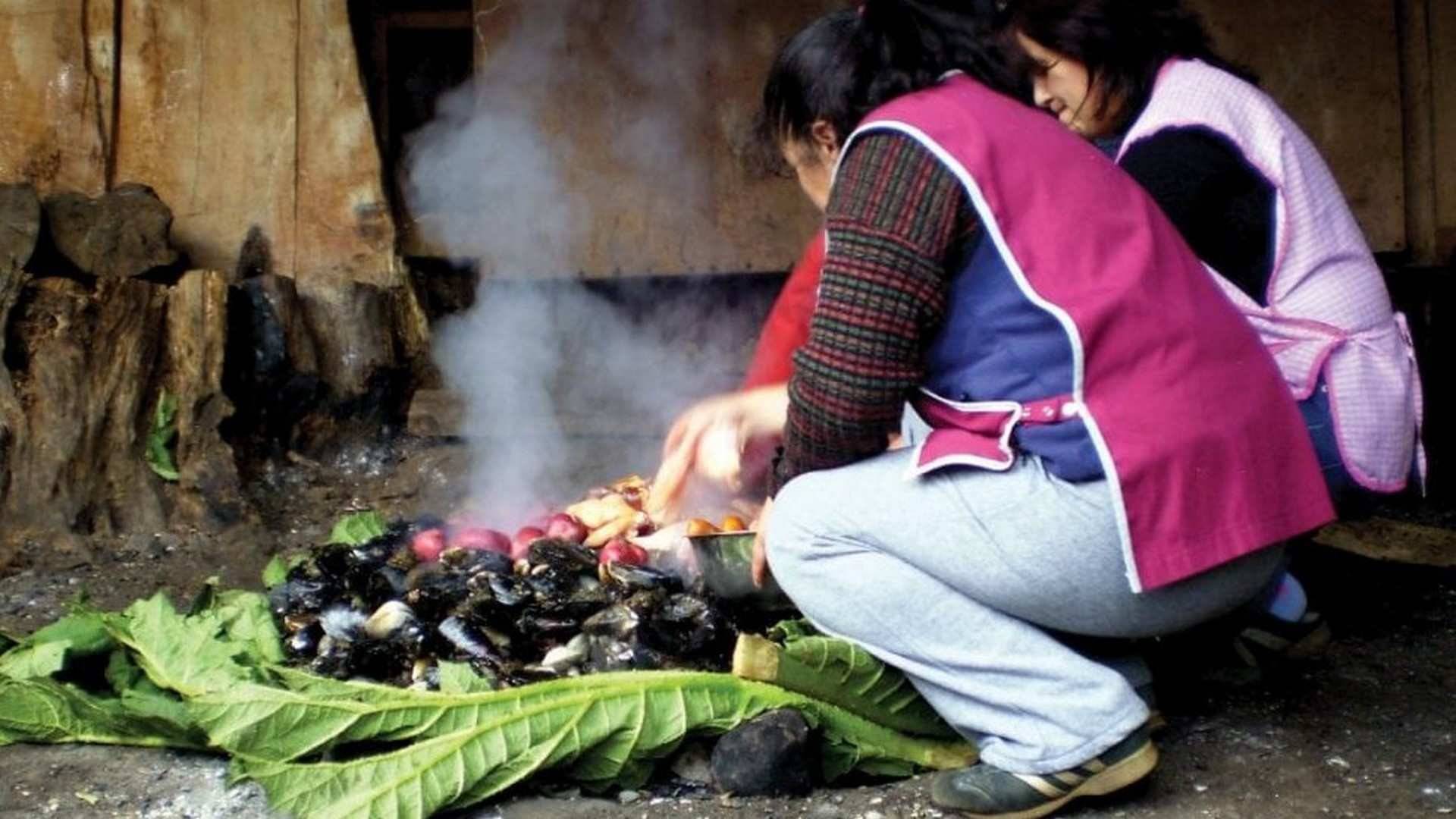 En el Curanto se utiliza un hueco en la tierra para cocinar sin otro material combustible que el calor de las piedras. Foto: © Contourstravel
