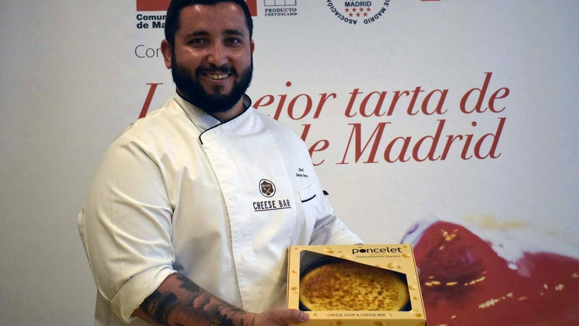 Carlos Sierra feliz muestra la tarta con la que ha conseguido el primer puesto en el Concurso de la Mejor Tarta de Queso de Maddrid.
